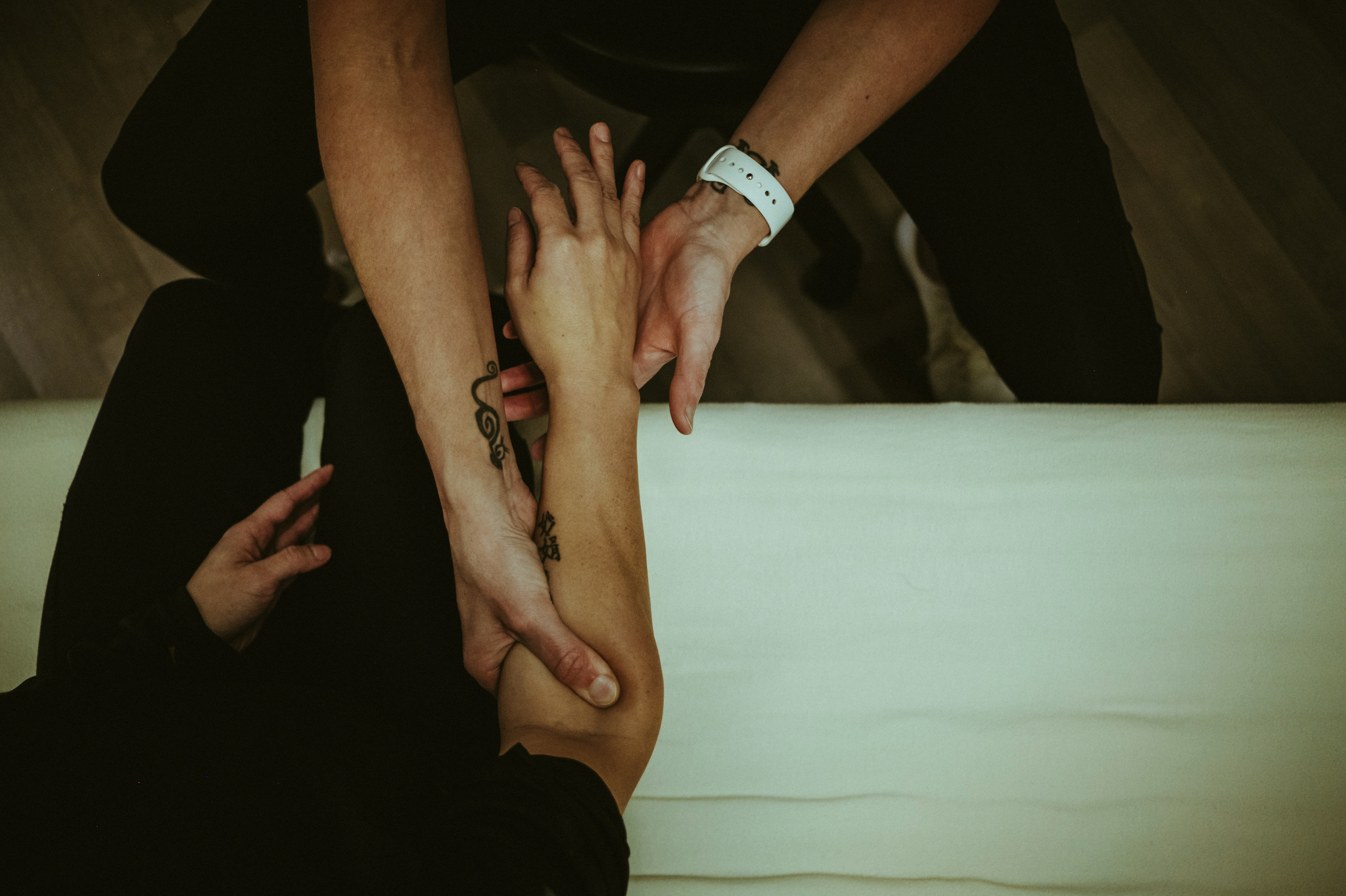 Hands-on Active Release Techniques® treatment on the forearm, showing precise pressure and guided client participation